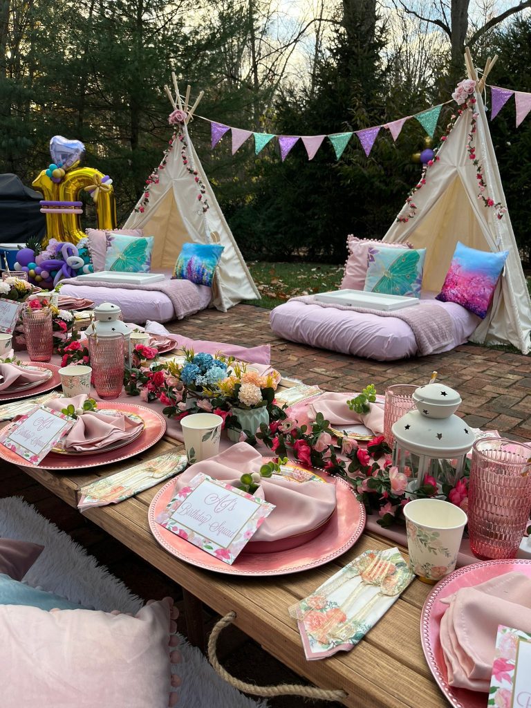 Outdoor picnic setup with Enchanted Garden theme teepees